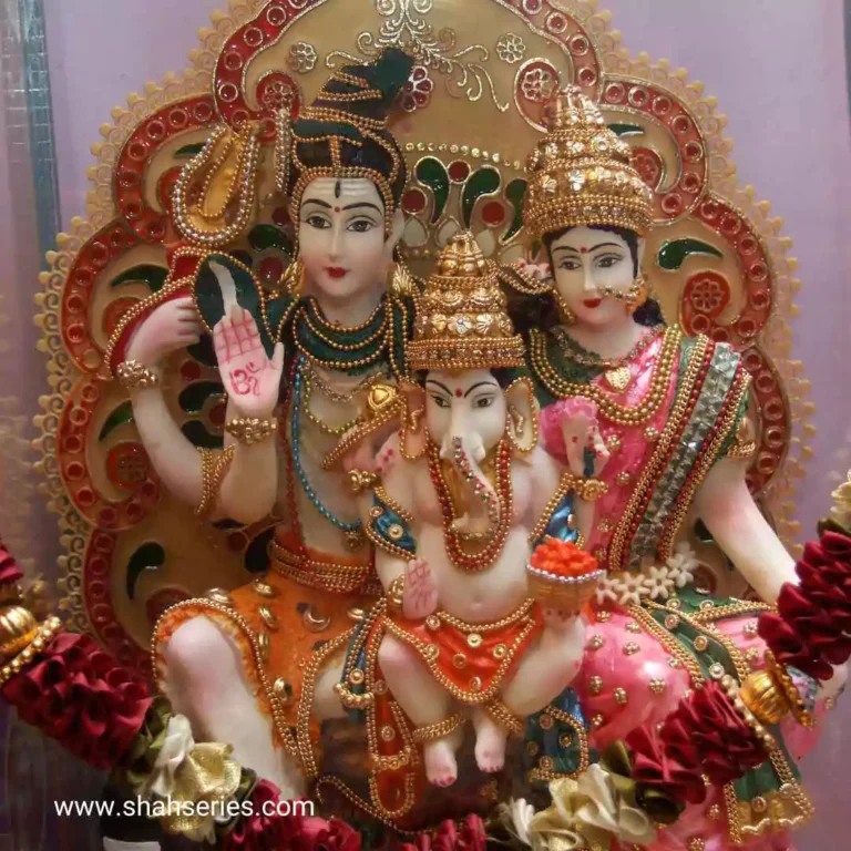 The image is about a couple of Shiv Parvati wearing traditional Indian attire. They are indoors, possibly in a temple.