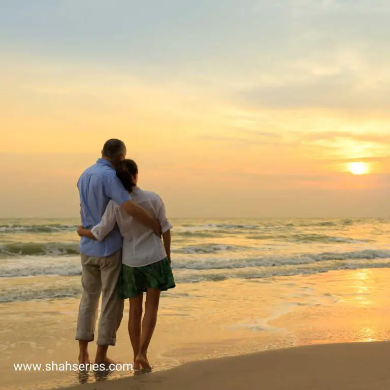 a couple standing at beach before sunset