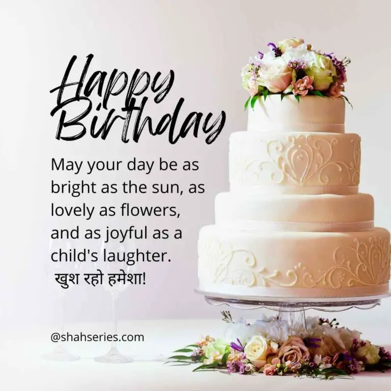The photo is a cake with flowers on it. The text on the cake reads "Happy Birthday May your day be as bright as the sun, as lovely as flowers, and as joyful as a child's laughter. खुश रहो हमेशा! @shahseries.com." The cake is decorated with roses and is on a cake stand.